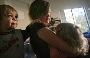 Kelli Roman breast-feeds her 22-month-old daughter Ivy with her 3-year-old son Abe at her side at her Fallbrook apartment. 