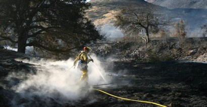 A CalFire firefighter douses hotspots of a fire that burned hillsides on the north side of Highway 76 close to a mile west of the Pala Casino on Sunday afternoon. A CalFire firefighter douses hotspots of a fire that burned hillsides on the north side of Highway 76 close to a mile west of the Pala Casino on Sunday afternoon.