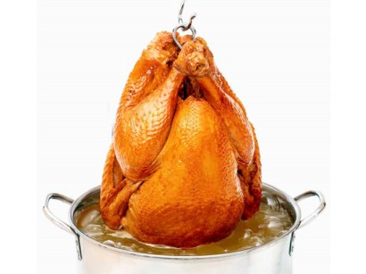 Turkey being pulled out of deep fryer. Turkey being pulled out of deep fryer.