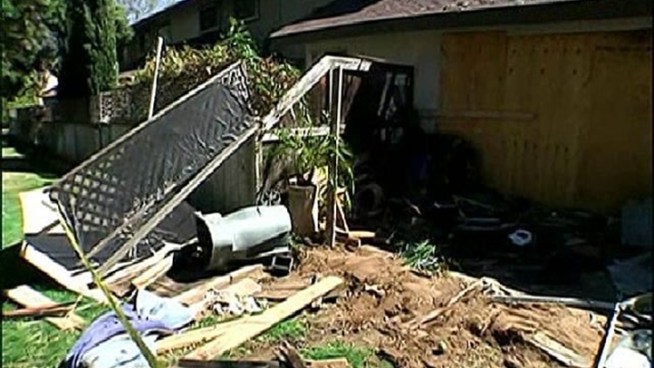 An Escondido backyard was in shambles Friday after a car hopped the curb and crashed through the fence hitting the homeowner.
