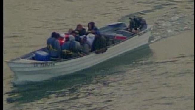 A panga boat filled with more than a dozen people, believed to be illegal immigrants, was towed to shore.
