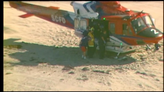 Firefighters and lifeguards transport a cliff fall victim from Blacks Beach in La Jolla to Scripps La Jolla Friday morning.