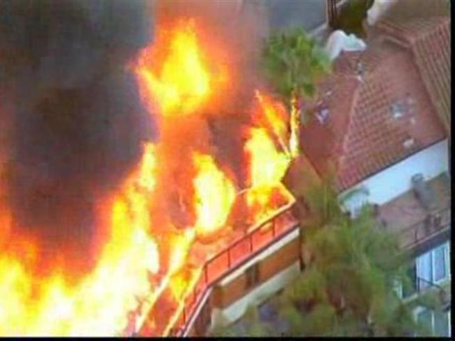 Fire crews knock down a blaze before it can spread to nearby homes.