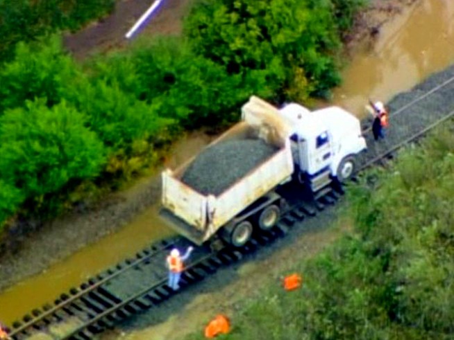 Heavy rain severely eroded soil under train tracks.