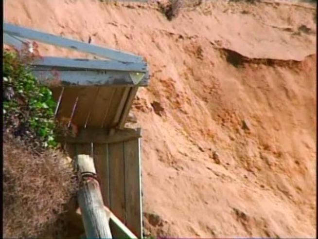 She must wait for permission to fix a cliff that collapsed behind her home.