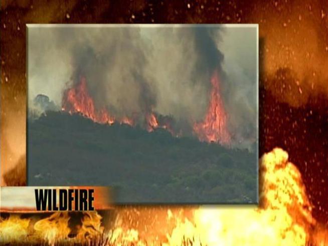 A brush fire burning near the <a title=