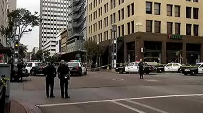 A 57-year-old woman suffered critical injuries when her husband shot her in the head and arm Saturday afternoon on a busy downtown street, police said.
