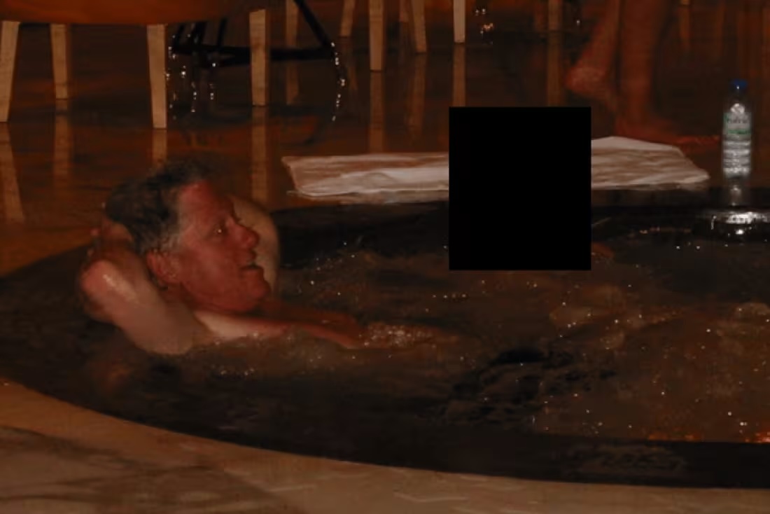 Photo appears to show Bill Clinton in a hot tub next to a person whose face has been redacted.