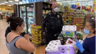An Escondido Police Department pays for a family's groceries as part of the department's "Operation Zero Total" initiative.