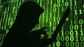 A generic photo of a person typing set against background of binary numbers