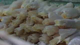 Employees at Las Cuatro Milpas in Barrio Logan prepare tamales for customers.