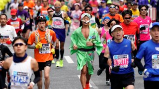 Runners in costumes make their way through Tokyo's Ginza shopping district at the Tokyo Marathon in Tokyo, Sunday, Feb. 25, 2018. About 36,000 people participated in the annual sport event. (AP Photo/Shizuo Kambayashi)