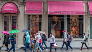 FILE- In this April 4, 2018, file photo, shoppers walk past the Victoria's Secret store on Broadway in the Soho neighborhood of New York.