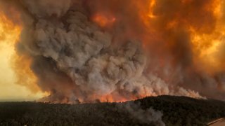 Wildfires rage under plumes of smoke in Bairnsdale, Australia on Dec. 30, 2019.
