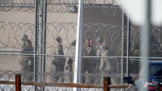 In this Feb. 18, 2020, file photo prisoners stand outside of the federal correctional institution in Englewood, Colo. Inmates at all 122 federal correctional facilities across the country will no longer be allowed visits from family, friends or attorneys for the next 30 days, in response to the threat of the coronavirus, officials told.