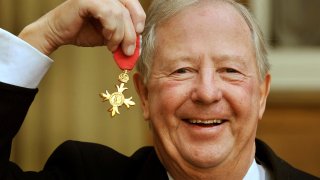 Tim Brooke-Taylor holds his OBE after being presented it by Queen Elizabeth, outside Buckingham Palace in London.