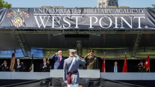 President Donald Trump, left, and United States Military Academy superintendent Darryl A. Williams, right, salute alongside graduating cadets at West Point