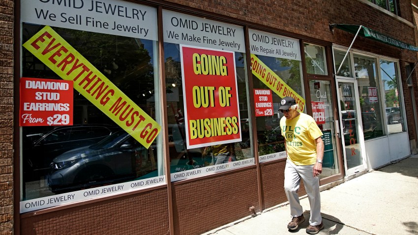 In this June 23, 2020, file photo, a man walks past a retail store that is going out of business due to the coronavirus pandemic in Winnetka, Ill.