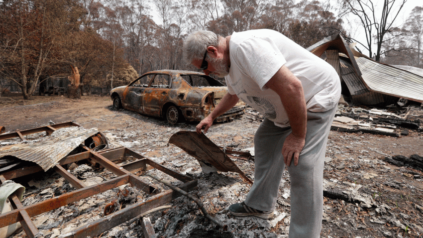 Lyle Stewart looks through burned debris at his destroyed house at Nerrigundah, Australia, Monday, Jan. 13, 2020, after a wildfire ripped through the town on New Year’s Eve.