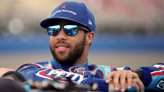 Bubba Wallace, driver of the #43 Victory Junction Chevrolet, stands by his car before qualifying for the NASCAR Cup Series Auto Club 400 at Auto Club Speedway, Feb. 29, 2020, in Fontana, Calif.