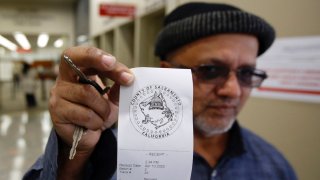 HOLD TO MOVE SATURDAY APRIL 11 WITH STORY — In this photo taken Friday April 10, 2020, Tahir Mehood displays the receipt he received after paying his Sacramento County property tax in Sacramento, Calif. The coronavirus outbreak has delayed income taxes, mortgage payments and even evictions in California. But Gov. Gavin Newsom did not delay the property tax   deadline for the state’s homeowners to pay their property taxes without a penalty.  Some counties did delay the deadline, while others say they will on a case by case basis. (AP Photo/Rich Pedroncelli)