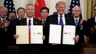 President Donald Trump signs a trade agreement with Chinese Vice Premier Liu He, in the East Room of the White House, Wednesday, Jan. 15, 2020, in Washington.