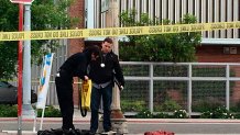 In this April 18, 2017, file photo, Fresno police stand next to a pile of clothes in the neighborhood where shootings occurred in Fresno, Calif.