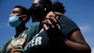 Isaiah Chatman, left, and his girlfriend, Angelah Hackney, both of Oakland, hold their hands while listening to a speaker before marching in Dublin.