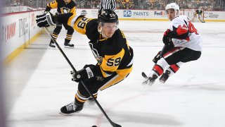 Jake Guentzel #59 of the Pittsburgh Penguins handles the puck against the Ottawa Senators at PPG PAINTS Arena on December 30, 2019 in Pittsburgh, Pennsylvania.