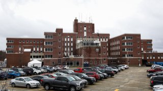 In this April 3, 2020, file photo, cars pack the parking lot outside of the Holyoke Soldier’s Home in Holyoke, Mass.