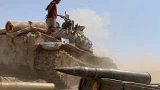 A fighter loyal to Yemen's separatist Southern Transitional Council (STC) stands atop a tank amid clashes with Saudi-backed government forces for control of Zinjibar, the capital of the southern Abyan province, in the Sheikh Salim area on May 23, 2020.