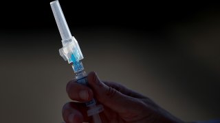 A nurse holds a vaccine.