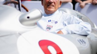 Sir Stirling Moss sits in his Mercedes
