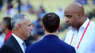 Major League Baseball Commissioner Rob Manfred talks with Executive Director of the Major League Baseball Players Association Tony Clark during batting practice prior to Game 2 of the 2017 World Series between the Houston Astros and the Los Angeles Dodgers at Dodger Stadium on Wednesday, October 25, 2017 in Los Angeles, California.