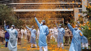 In this May 3, 2020, file photo, an Indian Air Force helicopter showers flower petals on the staff of INS Asvini hospital in Mumbai, India as part of Armed Forces’ efforts to thank the workers, including doctors, nurses and police personnel, who have been at the forefront of the country’s battle against the COVID-19 pandemic. Many cities across the world erupt at sundown with collective cheers thanking front-line workers for their selfless battle. But in Egypt, India, the Philippines, Mexico and elsewhere, doctors have been attacked, intimidated and treated as pariahs because of their work.