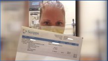 Patient with face protection holds hospital bill