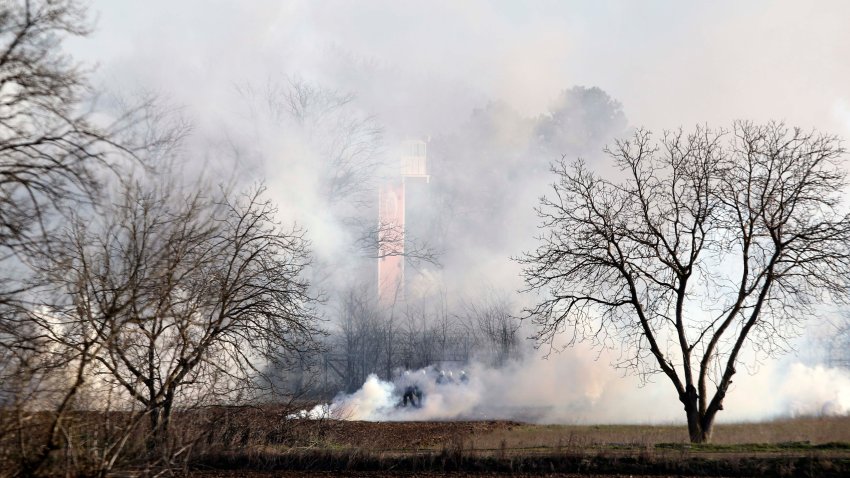 Greek riot police police is seen through smoke during clashes at the Greek-Turkish border in Kastanies, Evros region, on Friday, March 6, 2020. Thousands of refugees and other asylum-seekers have tried to enter Greece from the land and sea in the week since Turkey declared its previously guarded gateways to Europe open.