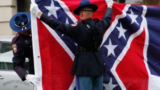 A Mississippi Highway Safety Patrol honor guard carefully folds the retired Mississippi state flag after it was raised over the Capitol grounds one final time in Jackson, Miss., Wednesday, July 1, 2020. The banner was the last state flag with the Confederate battle emblem on it.