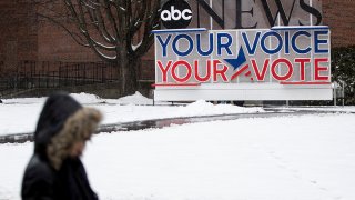 A person walks on the Saint Anselm College campus, Feb. 7, 2020, ahead of a Democratic party debate in Manchester, N.H.