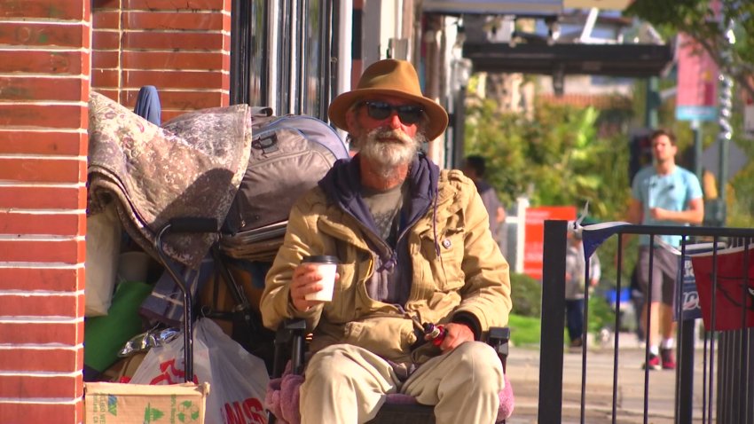 homeless man sits