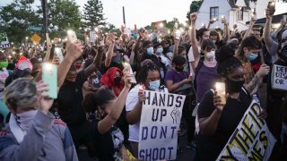 Demonstrators light candles during a youth led protest to defund the Oakland Police Department in front of Mayor Libby Schaaf's house in Oakland.