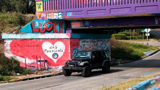 A vehicle drives by a tribute to victims of the Naval Air Station Pensacola that was freshly painted on what’s known as Graffiti Bridge in downtown Pensacola, Fla., on Dec. 7, 2019.