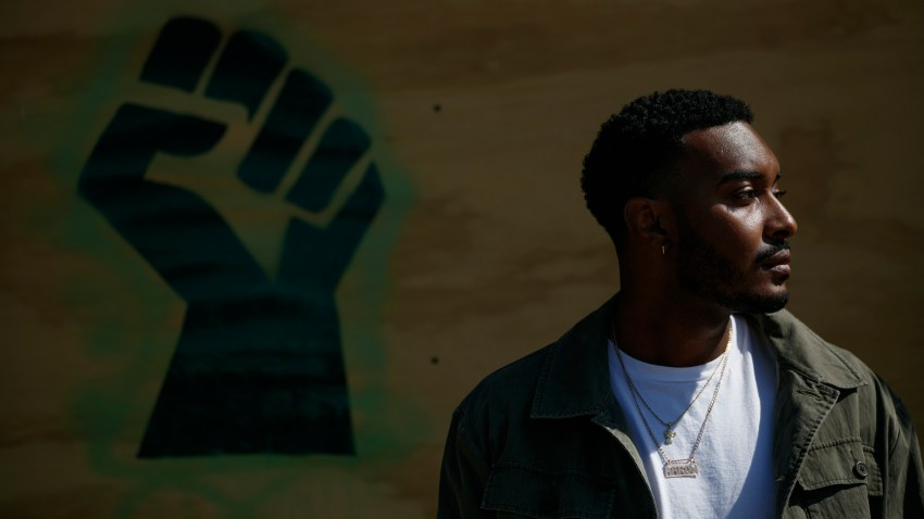 In this Friday, June 26, 2020, photo, Aaron Requena poses for a photo in the Van Nuys area of Los Angeles. The 25-year-old photographer says he's struggled to balance keeping up with what is happening with not torturing himself at the same time.