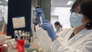 In this May 22, 2020, file photo, Bonghui Li works in a lab that is focused on fighting COVID-19 at Sorrento Therapeutics in San Diego, California.