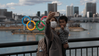 In this Wednesday, Jan. 29, 2020, file photo, a woman with a young boy takes a selfie with the Olympic rings, in Tokyo's Odaiba district. Tokyo Olympic organizers are trying to shoot down rumors that this summer's games might be cancelled or postponed because of the spread of a new virus.