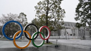 TOKYO, JAPAN – MARCH 29: The Olympic Rings are displayed in front of the National Stadium while snow falls on March 29, 2020 in Tokyo, Japan. (Photo by Masashi Hara/Getty Images)