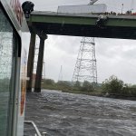 In this Monday, April 13, 2020, photo provided by the Chesapeake Fire Department, Chesapeake firefighters try to rescue the driver of a tractor trailer on the High Rise Bridge over the Elizabeth River, in Chesapeake, Va.
