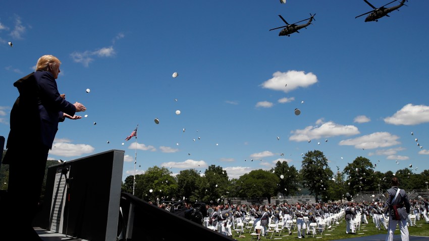 President Donald Trump applauds as Army helicopters fly over and West Point cadets toss their caps into the air at the end of commencement ceremonies on the parade field, at the United States Military Academy in West Point, N.Y., Saturday, June 13, 2020.