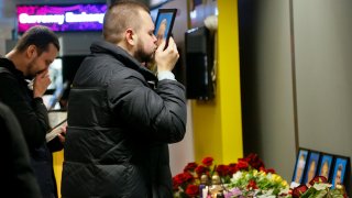 In this Jan. 8, 2020, file photo, the partner of Julia Sologub, a member of the flight crew of the Ukrainian 737-800 plane that crashed on the outskirts of Tehran, kisses a portrait of her at a memorial inside Borispil international airport outside Kyiv, Ukraine.