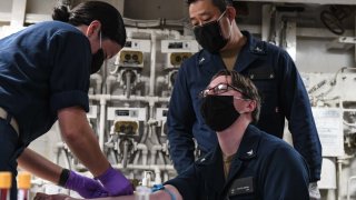 U.S. Navy Lt. j.g. Pamichella Torres, assigned to Naval Hospital Okinawa, left, draws blood from U.S. Navy Hospital Corpsman 3rd Class Shea Ashmore-Scianna, assigned to Naval Hospital Guam, to test for COVID-19 antibodies June 19, 2020. The Theodore Roosevelt Carrier Strike Group is on a scheduled deployment to the Indo-Pacific.